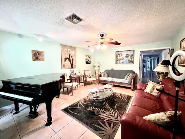 living room featuring a textured ceiling, ceiling fan, and light tile patterned flooring