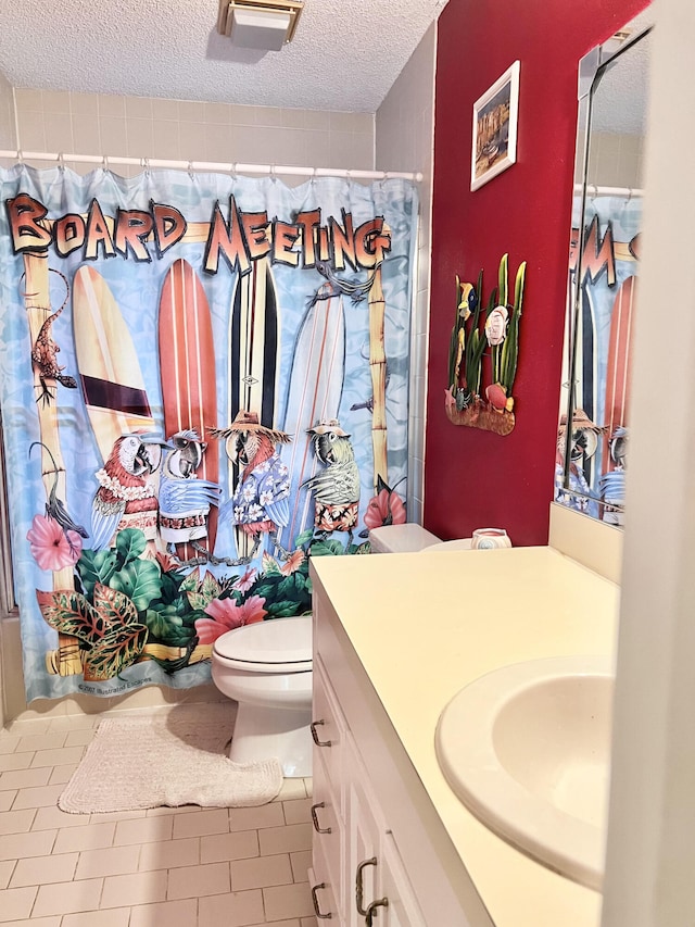 bathroom featuring vanity, a textured ceiling, toilet, and walk in shower