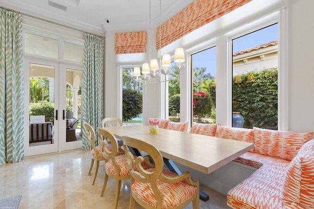 sunroom with breakfast area, french doors, and an inviting chandelier