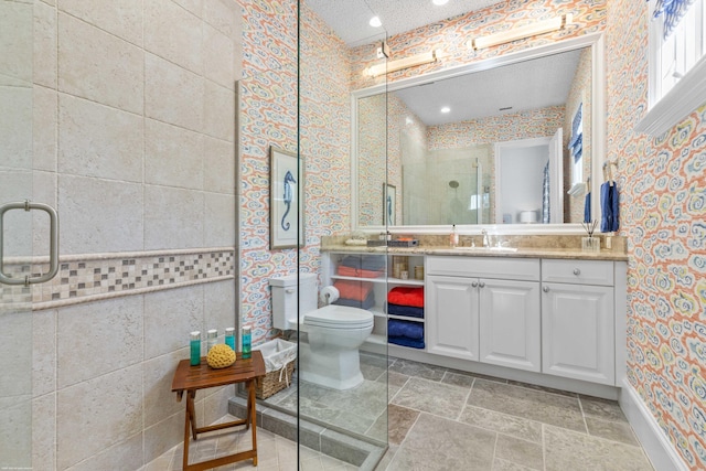 bathroom with vanity, toilet, tile walls, and a shower with shower door