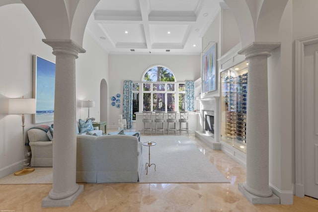 living room with beam ceiling, a towering ceiling, decorative columns, and coffered ceiling