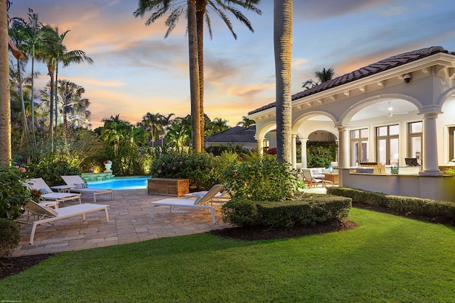 yard at dusk featuring a patio area