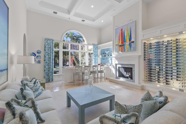 living room featuring coffered ceiling, ornamental molding, a towering ceiling, a fireplace, and beamed ceiling