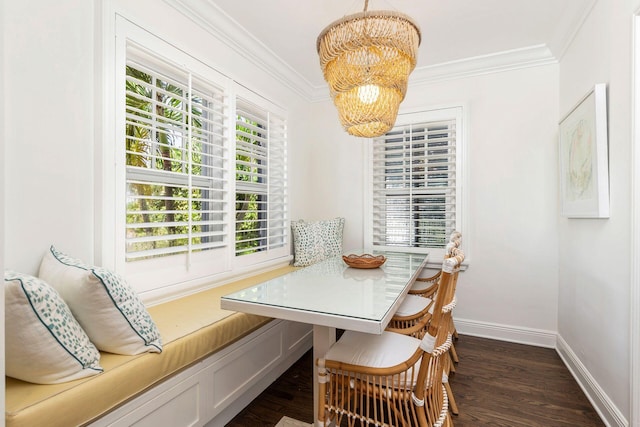 dining room with dark hardwood / wood-style flooring, crown molding, breakfast area, and a notable chandelier