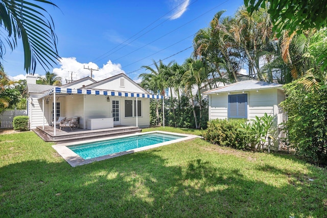 rear view of house with a yard, a fenced in pool, and a patio