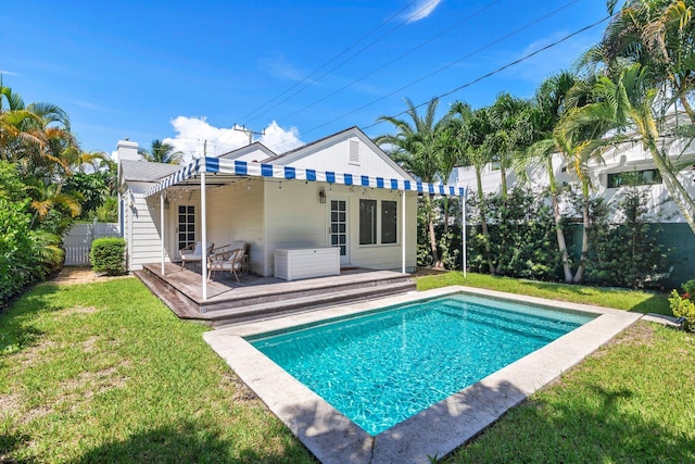 rear view of property featuring a lawn, a pergola, and a pool side deck