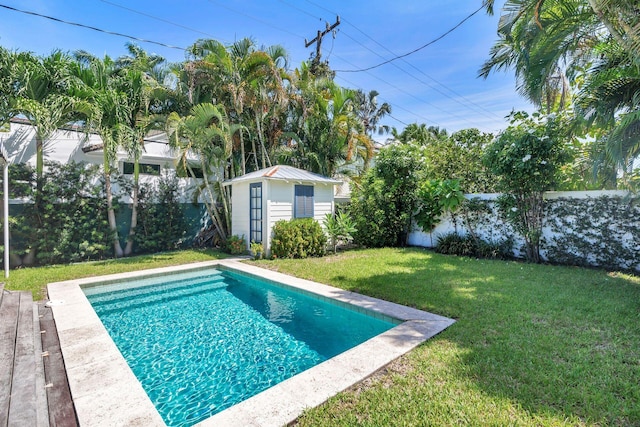 view of pool with a yard and a storage unit