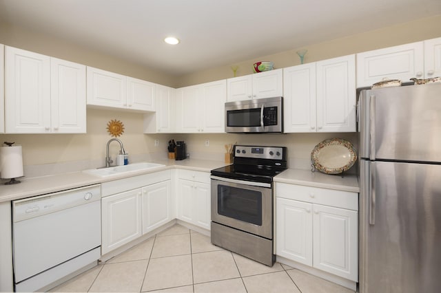 kitchen with light tile patterned floors, sink, white cabinetry, and appliances with stainless steel finishes