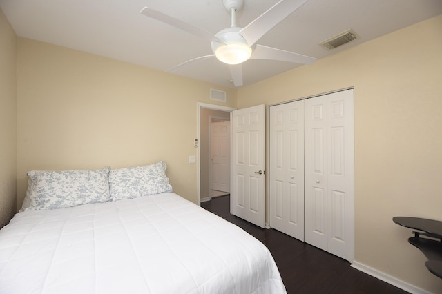 bedroom with dark wood-type flooring, ceiling fan, and a closet