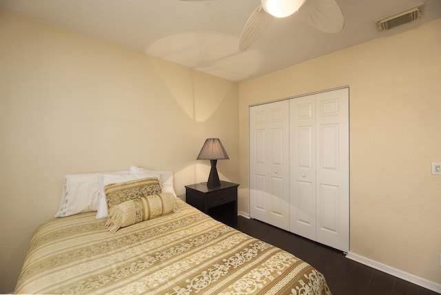 bedroom with dark wood-type flooring, a closet, and ceiling fan