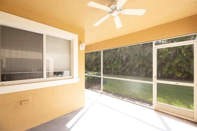 unfurnished sunroom featuring ceiling fan