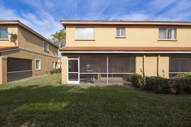 rear view of property featuring a sunroom and a lawn