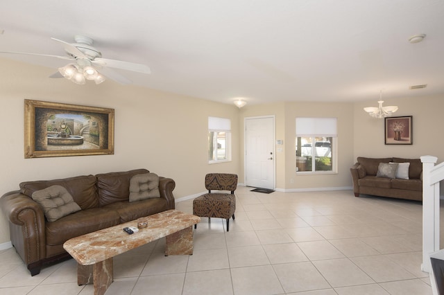 living room with light tile patterned floors and ceiling fan with notable chandelier