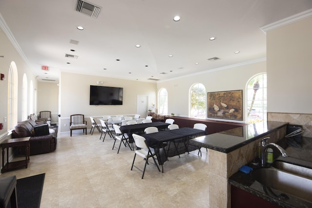 dining space with plenty of natural light, sink, and ornamental molding