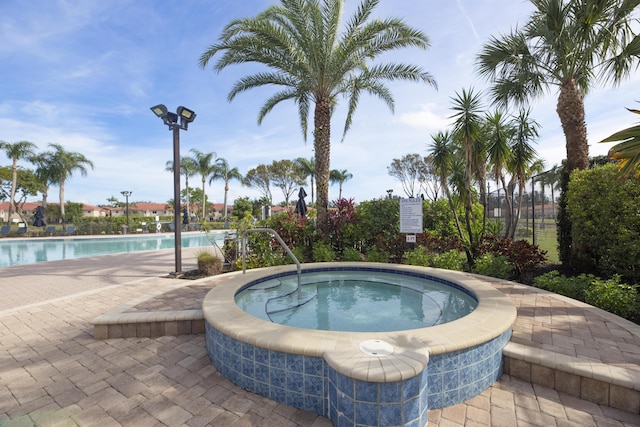 view of pool with a hot tub