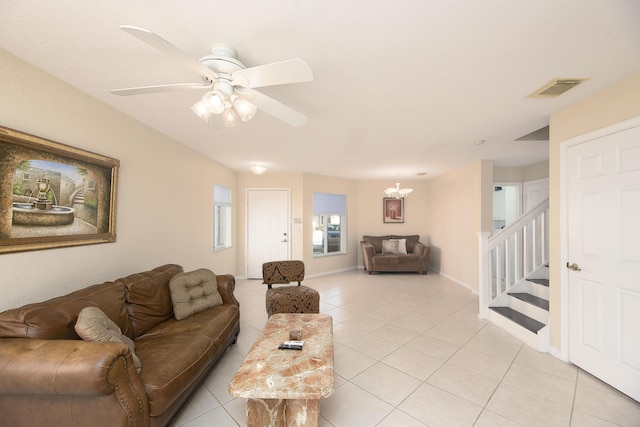 living room featuring ceiling fan with notable chandelier and light tile patterned floors