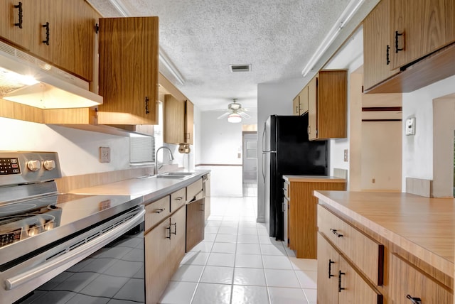 kitchen featuring light tile patterned floors, ceiling fan, electric stove, a textured ceiling, and sink