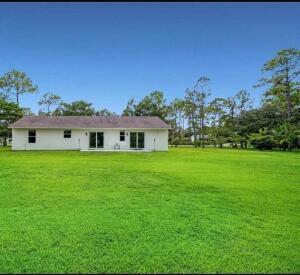 rear view of property featuring a lawn