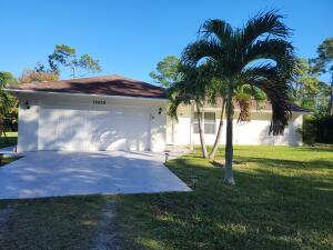 ranch-style house featuring a garage and a front lawn