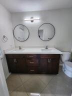 bathroom featuring toilet, vanity, and tile patterned floors