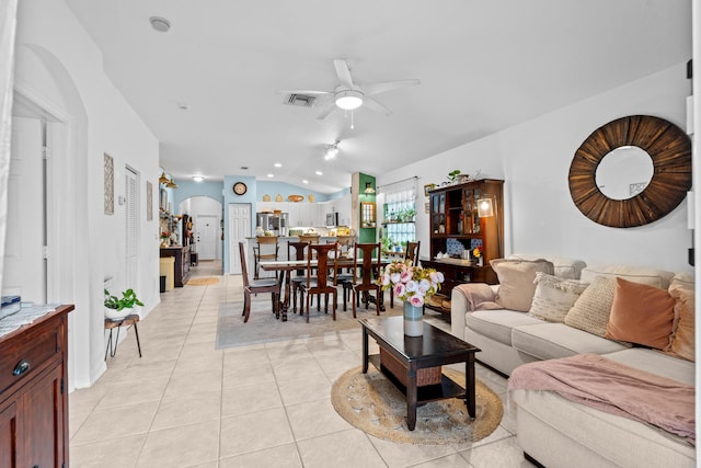 living room featuring ceiling fan, light tile patterned floors, and lofted ceiling