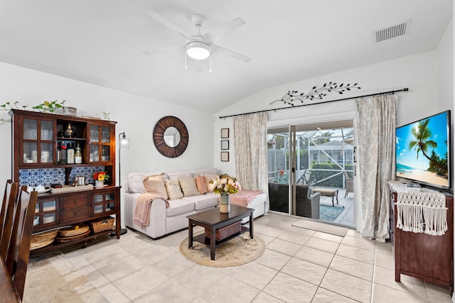 tiled living room with ceiling fan and lofted ceiling