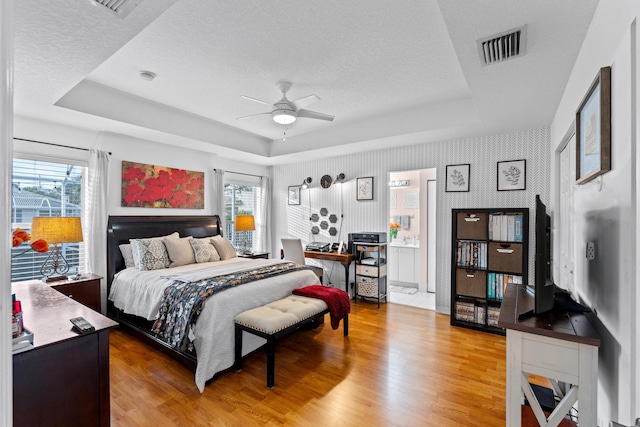 bedroom featuring hardwood / wood-style flooring and a tray ceiling