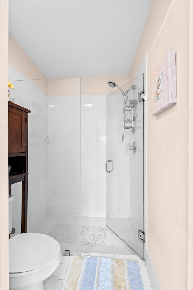 bathroom featuring toilet, tile patterned floors, and walk in shower