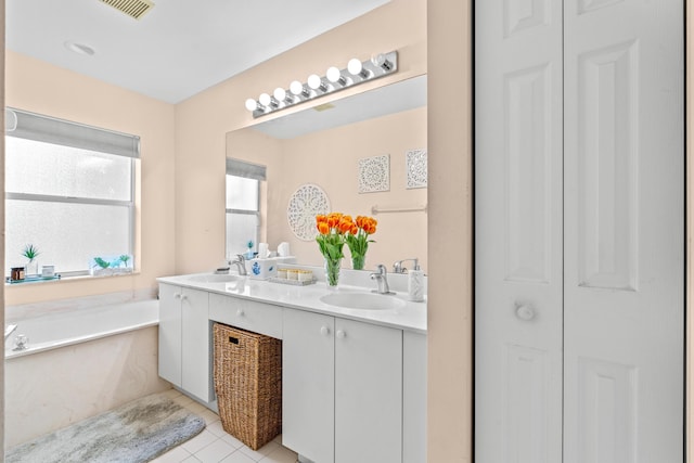 bathroom featuring tile patterned floors, vanity, and a tub to relax in