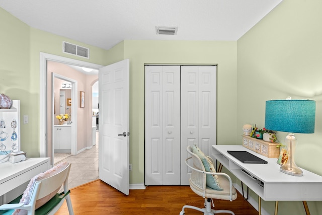 home office with light hardwood / wood-style flooring