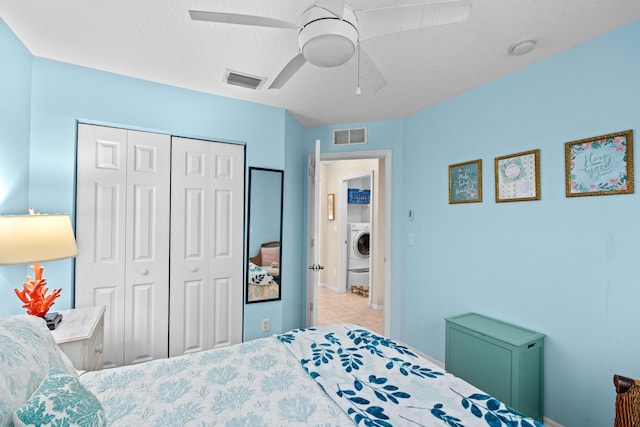 bedroom featuring a textured ceiling, ceiling fan, a closet, and washer / clothes dryer