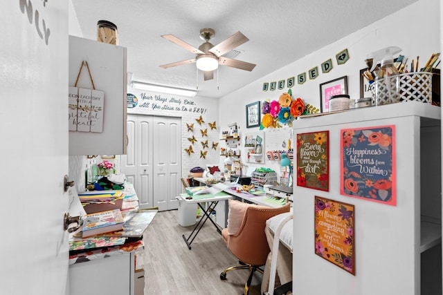 office space with ceiling fan, hardwood / wood-style floors, and a textured ceiling