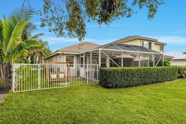 back of property with a lawn and glass enclosure