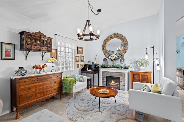 living room with light tile patterned floors, a chandelier, lofted ceiling, and a stone fireplace