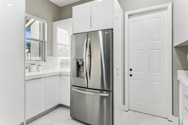 kitchen featuring white cabinetry and stainless steel refrigerator with ice dispenser