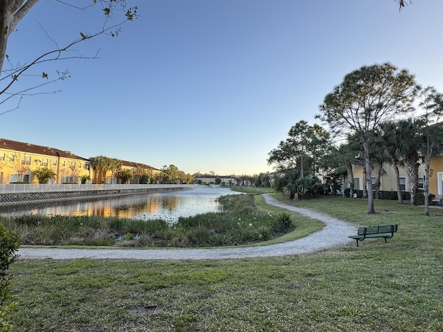 view of home's community featuring a lawn and a water view