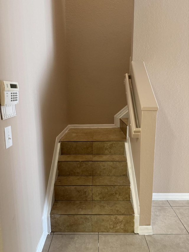 stairway featuring tile patterned flooring