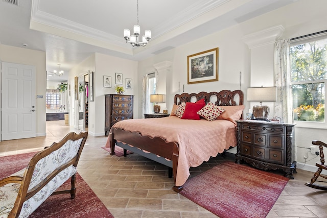 bedroom with ornamental molding, multiple windows, a tray ceiling, and a notable chandelier