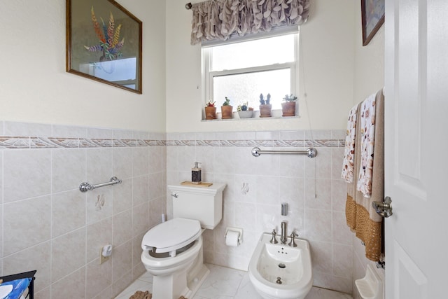 bathroom with tile walls, a bidet, and toilet