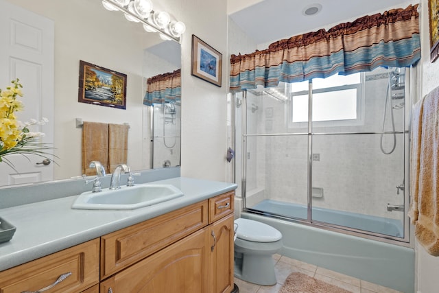 full bathroom with shower / bath combination with glass door, toilet, tile patterned floors, and vanity