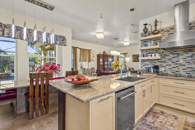 kitchen featuring light stone countertops, stainless steel dishwasher, wall chimney range hood, tasteful backsplash, and sink