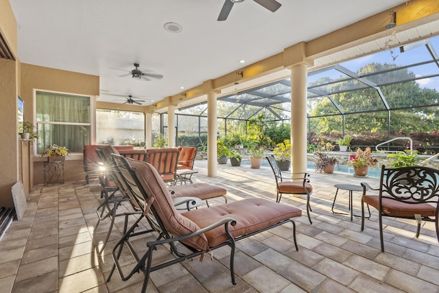 view of patio with ceiling fan, a swimming pool, and glass enclosure