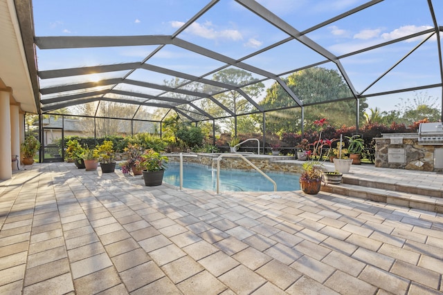 view of pool with exterior kitchen, a lanai, and a patio