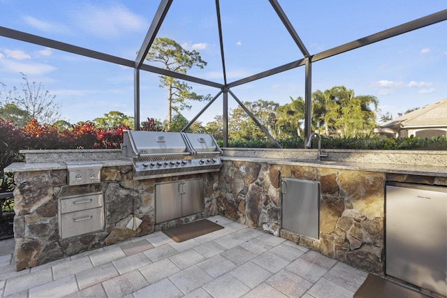 view of patio with sink, an outdoor kitchen, a lanai, and a grill