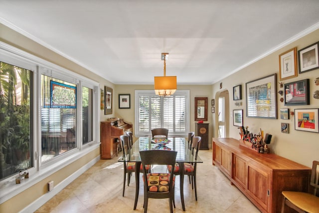 tiled dining room with a chandelier and ornamental molding