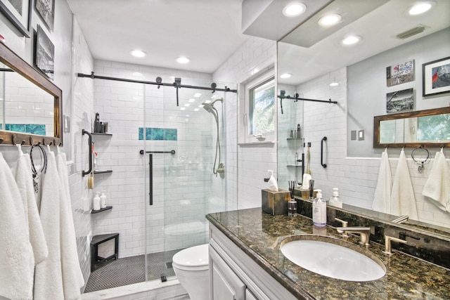 bathroom featuring toilet, vanity, tile walls, and walk in shower