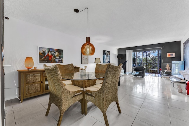 tiled dining area featuring a textured ceiling