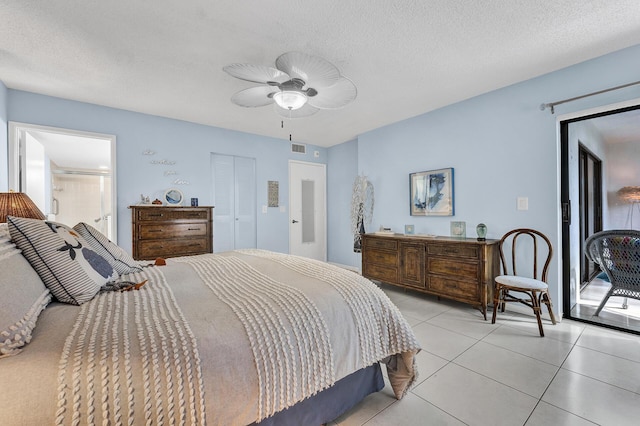 tiled bedroom with ceiling fan, a textured ceiling, and a closet