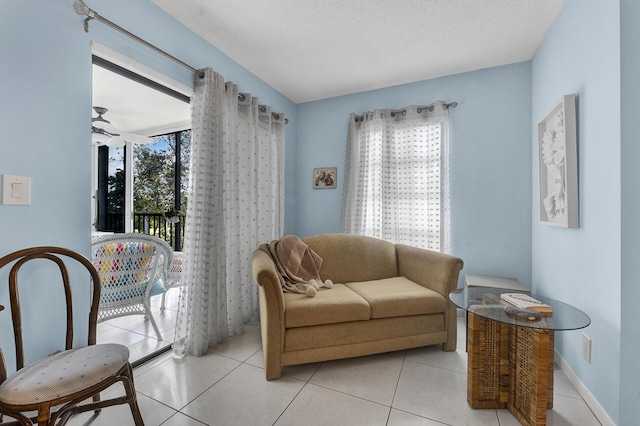 sitting room featuring ceiling fan, a textured ceiling, and light tile patterned floors