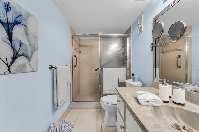 bathroom with an enclosed shower, vanity, toilet, and tile patterned flooring